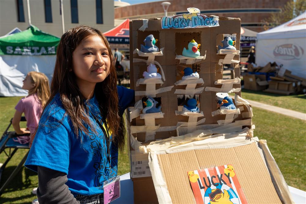 A student stands by a Lucky Duck display at Chandler Innovation Fair.